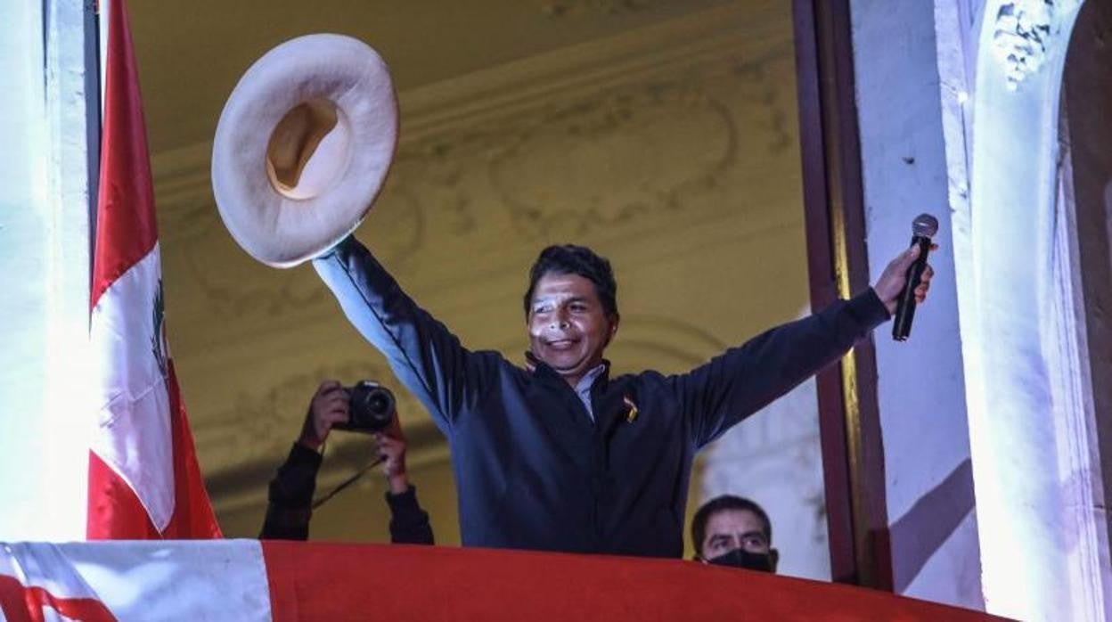 El candidato izquierdista a la presidencia de Perú Pedro Castillo saluda a seguidores desde un balcón de la sede de su partido Perú Libre hoy, en Lima