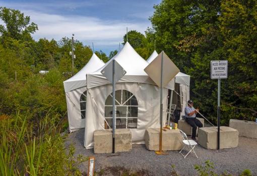 Agentes fronterizos en una carpa montada en la frontera por Roxham Road