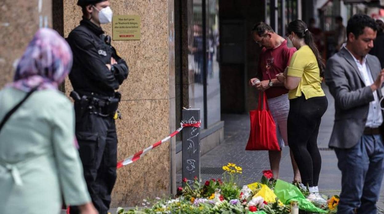 Personas colocan flores y velas en un memorial improvisado en homenaje a las víctimas del ataque