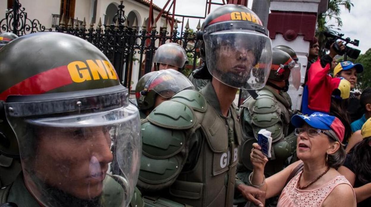 Una mujer se manifiesta frente a agentes de la Guardia Nacional Bolivariana en Caracas en 2017