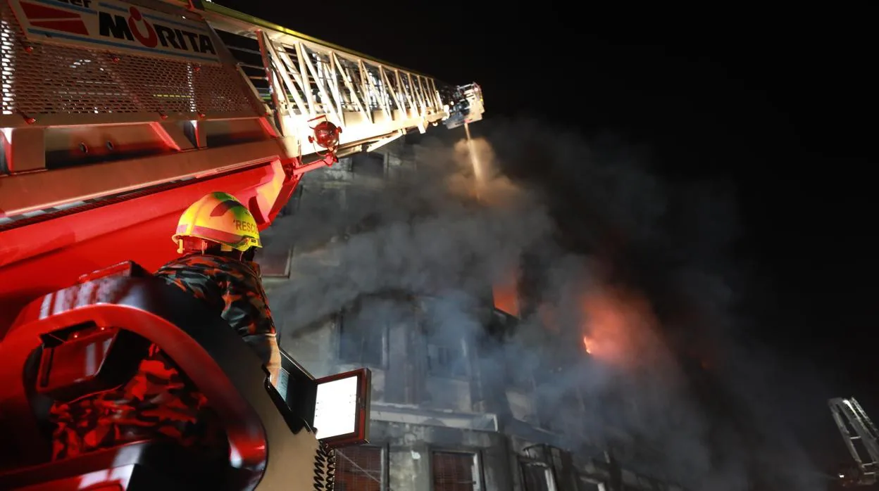Un camión de bomberos intenta apagar las llamas de la fábrica