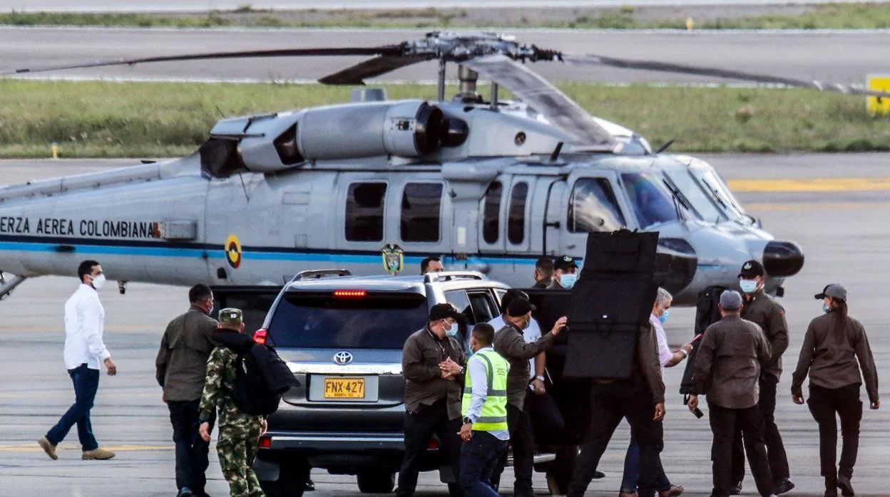 El presidente de Colombia, Iván Duque, camina rodeado de guardaespaldas cerca del helicóptero presidencial