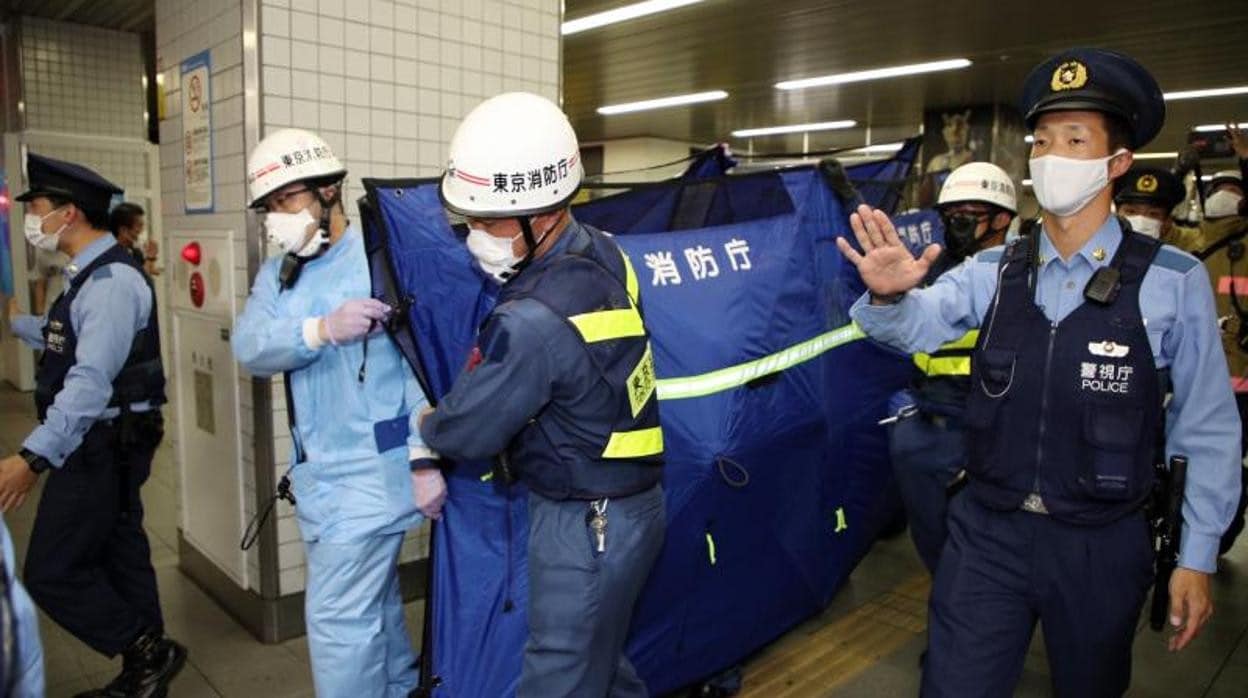 Los equipos de emergencia evacúan a un herido tras el ataque en un tren de Tokio