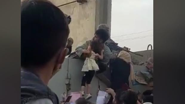 Una niña afgana, levantada por la multitud, símbolo de la desesperación por huir de Kabul