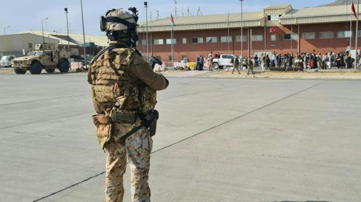 Un soldado en la pista esperando que los pasajeros, que huyeron de Afganistán, suban a un avión militar italiano