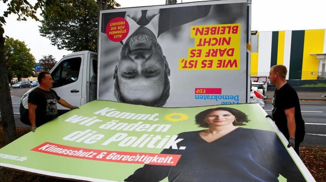 Trabajadores retiran los carteles de la campaña electoral después de las elecciones generales en Alemania