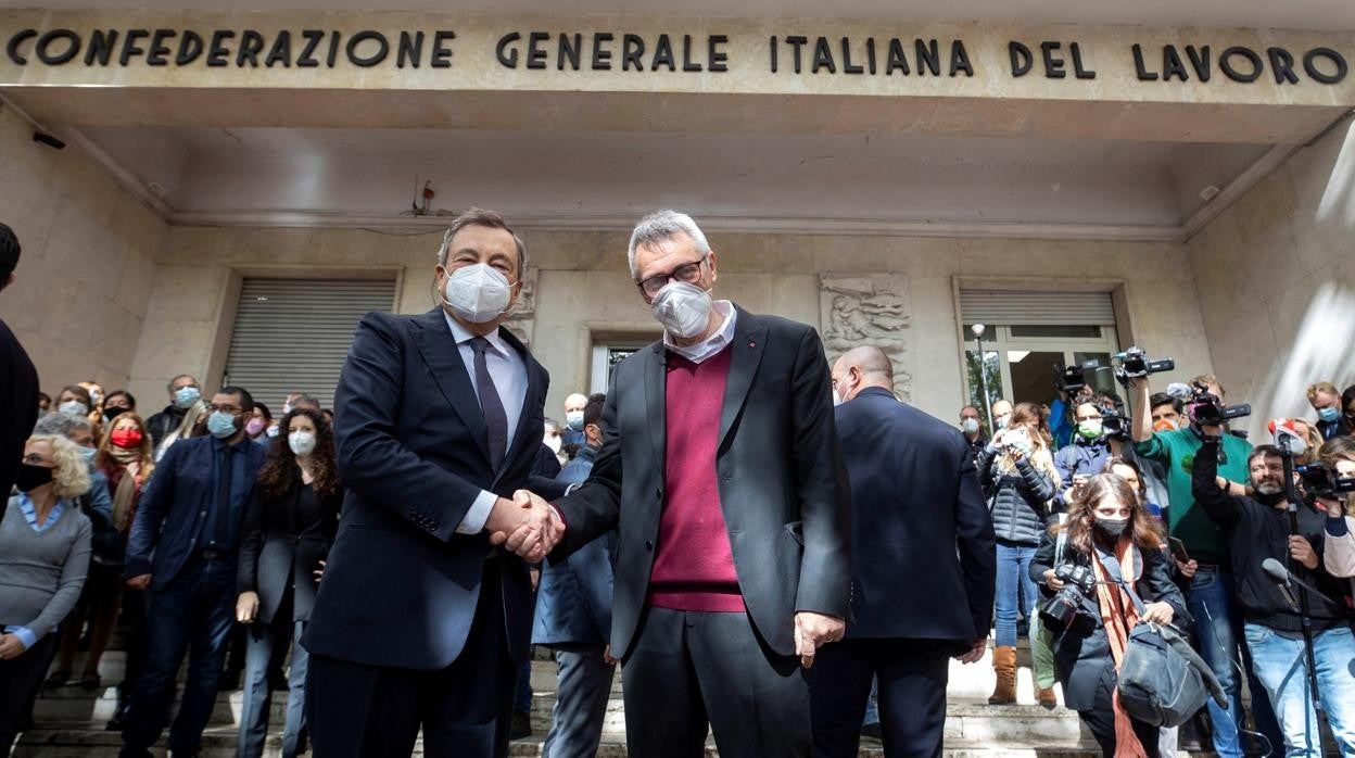 El primer ministro Mario Draghi con el secretario general del CGIL Maurizio Landini. cuya sede en Roma fue asaltada el sábado