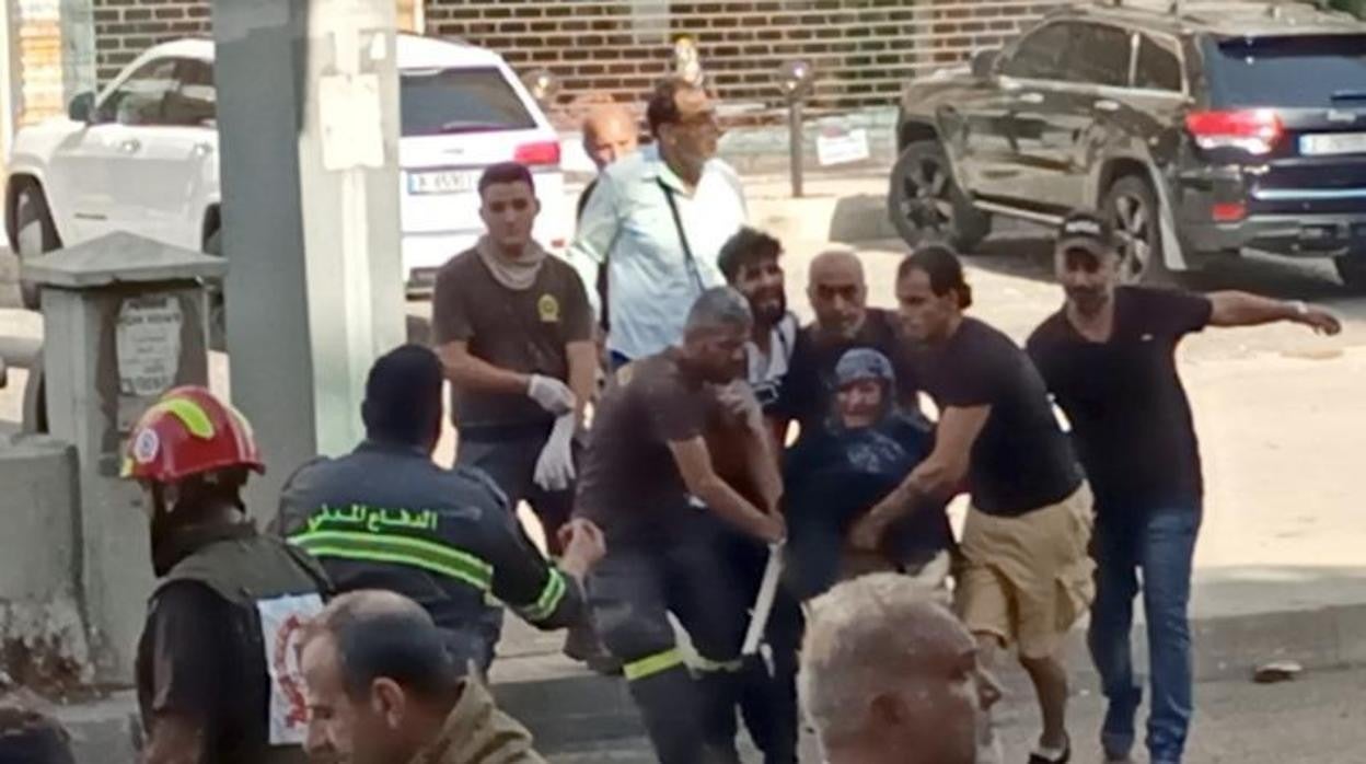 Una mujer es evacuada durante el tiroteo en Beirut