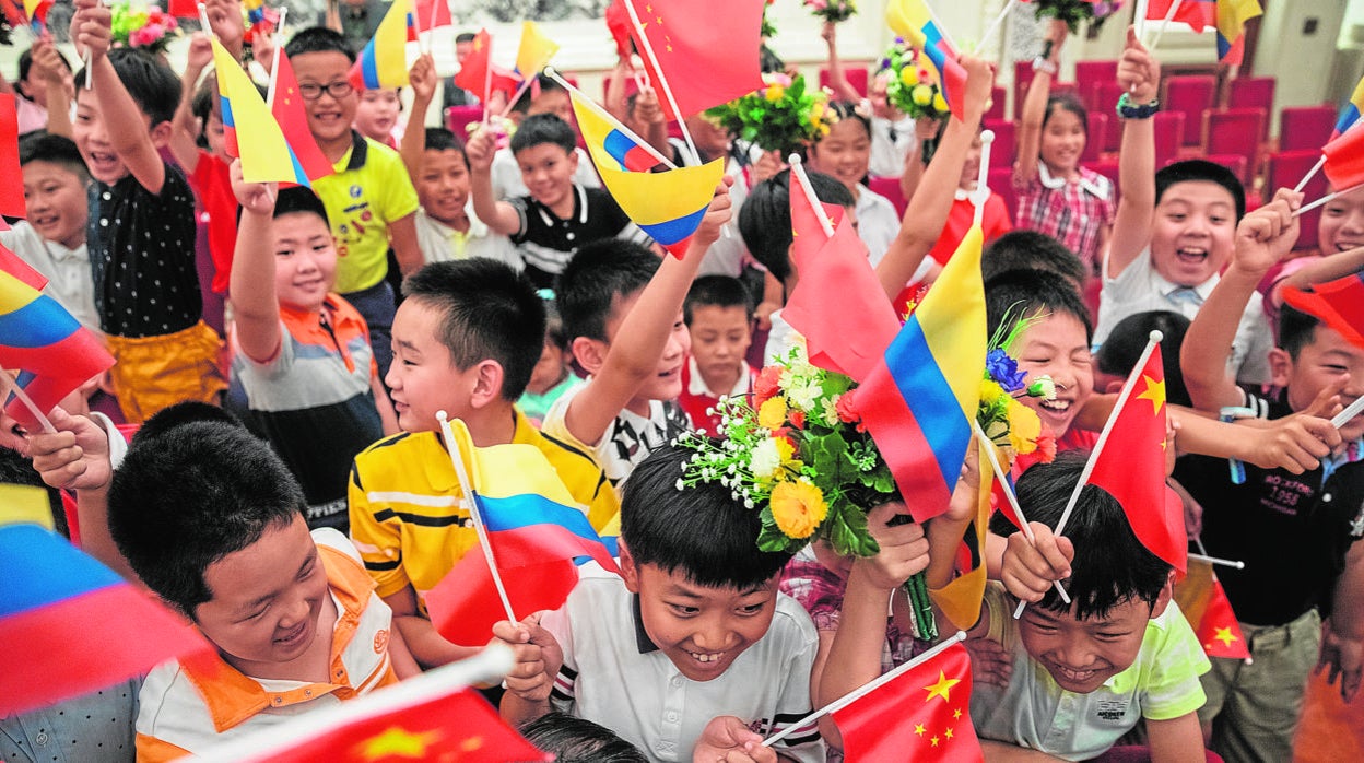 Niños con banderas colombianas y chinas reciben al presidente de Colombia, Iván Duque, en una visita a Pekín