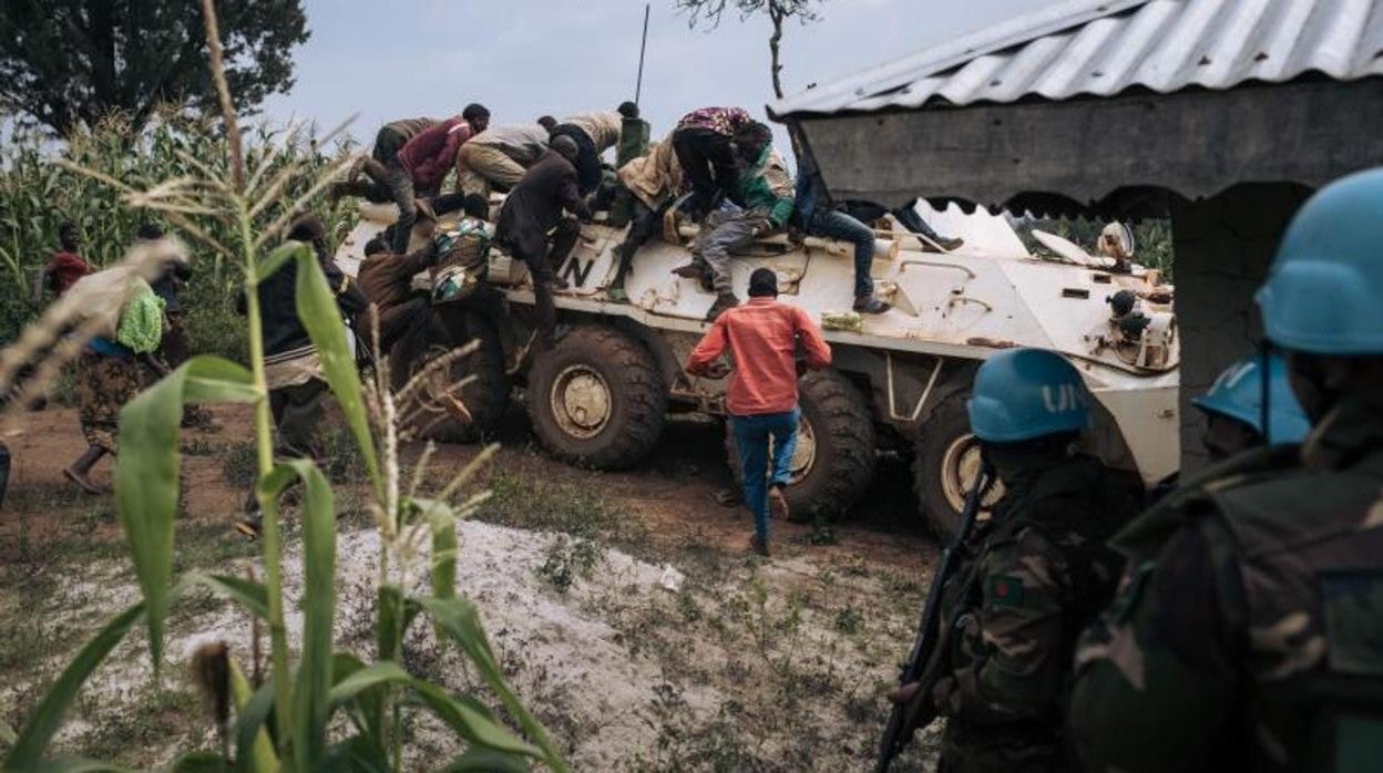 Voluntarios de Cruz Roja se suben a un blindado de la ONU para protegerse de las balas en diciembre pasado