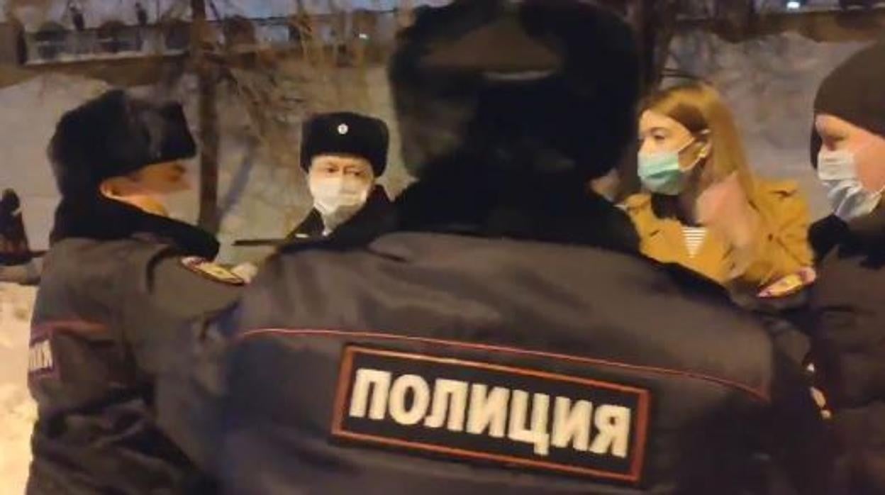 Captura del momento en el que la manifestante es rodeada por la Policía rusa para ser detenida
