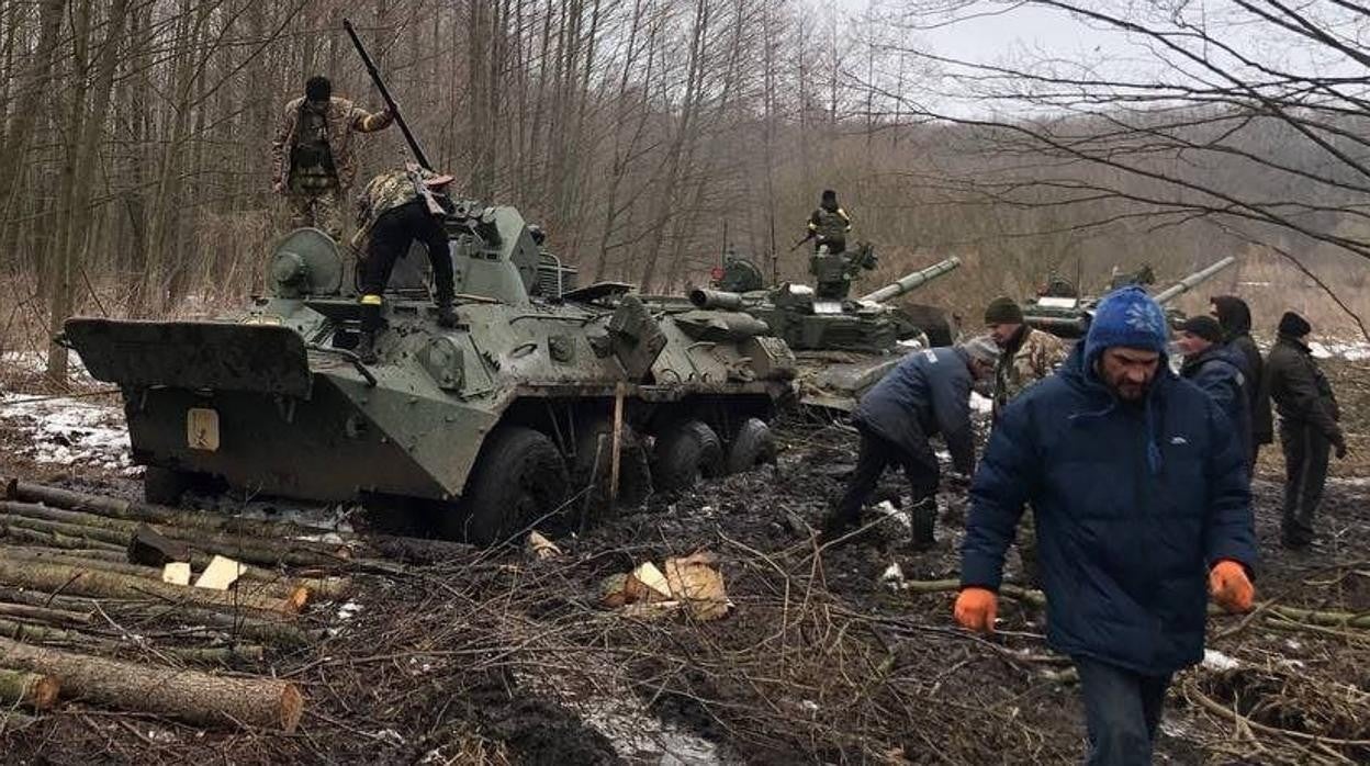 Dos carros de combate rusos T-72 ( derecha) y un vehículo blindado de transporte BTR-82A APC, en el lodo
