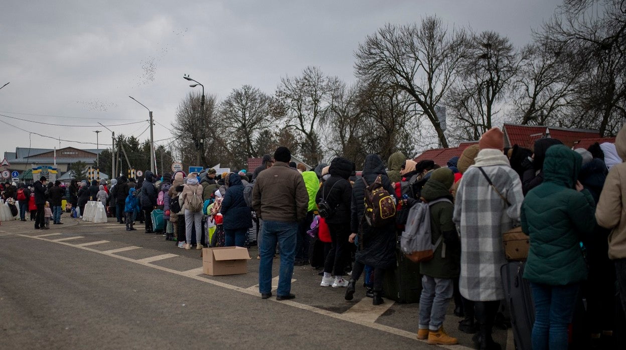 Cientos de personas, la mayoría mujeres y niños, esperan para cruzar a Rumanía en el paso fronterizo de Porubne, al oeste de Ucrania.