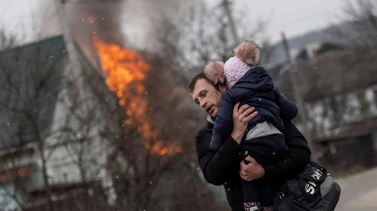 Un padre ucraniano huye con su hijo en brazos tras un ataque de las fuerzas rusas