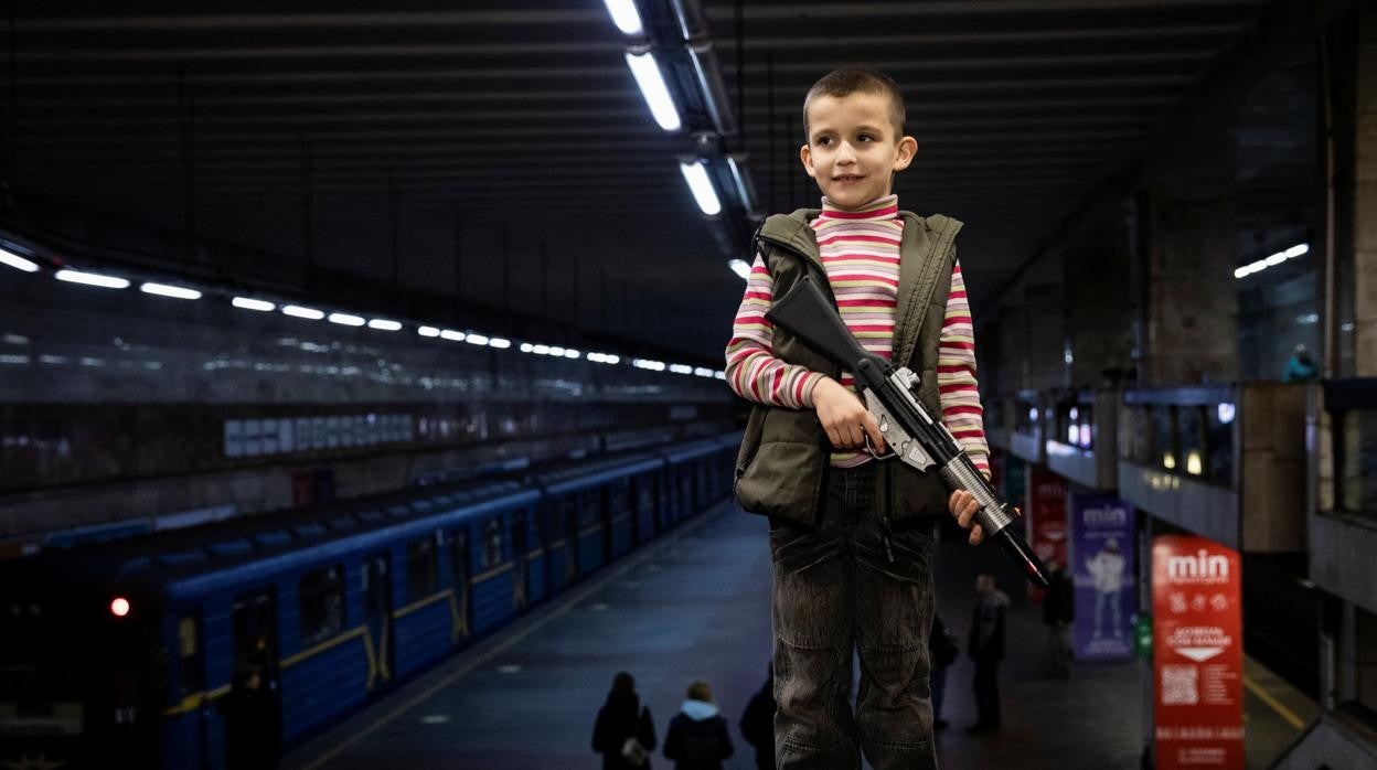 Un niño sostiene un arma de juguete en la estación que sirve de búnker durante los bombardeos