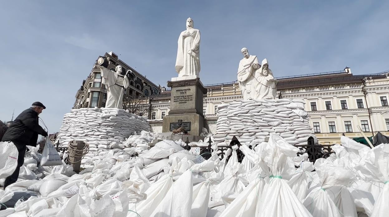 Voluntarios colocan sacos terreros para proteger varias esculturas en la plaza Mykhailivska de Kiev