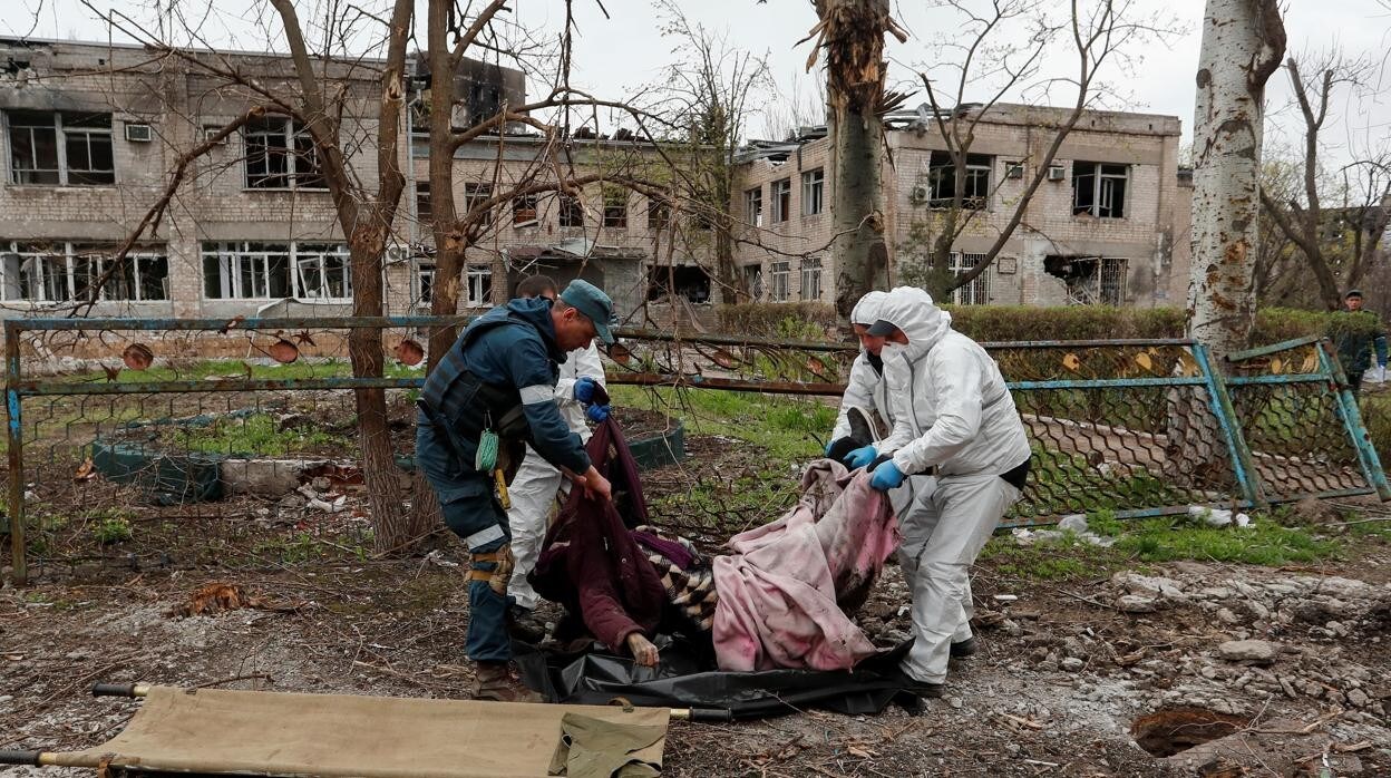 Un equipo de emergencias transportan el cuerpo de una persona muerta durante la guerra de Ucrania