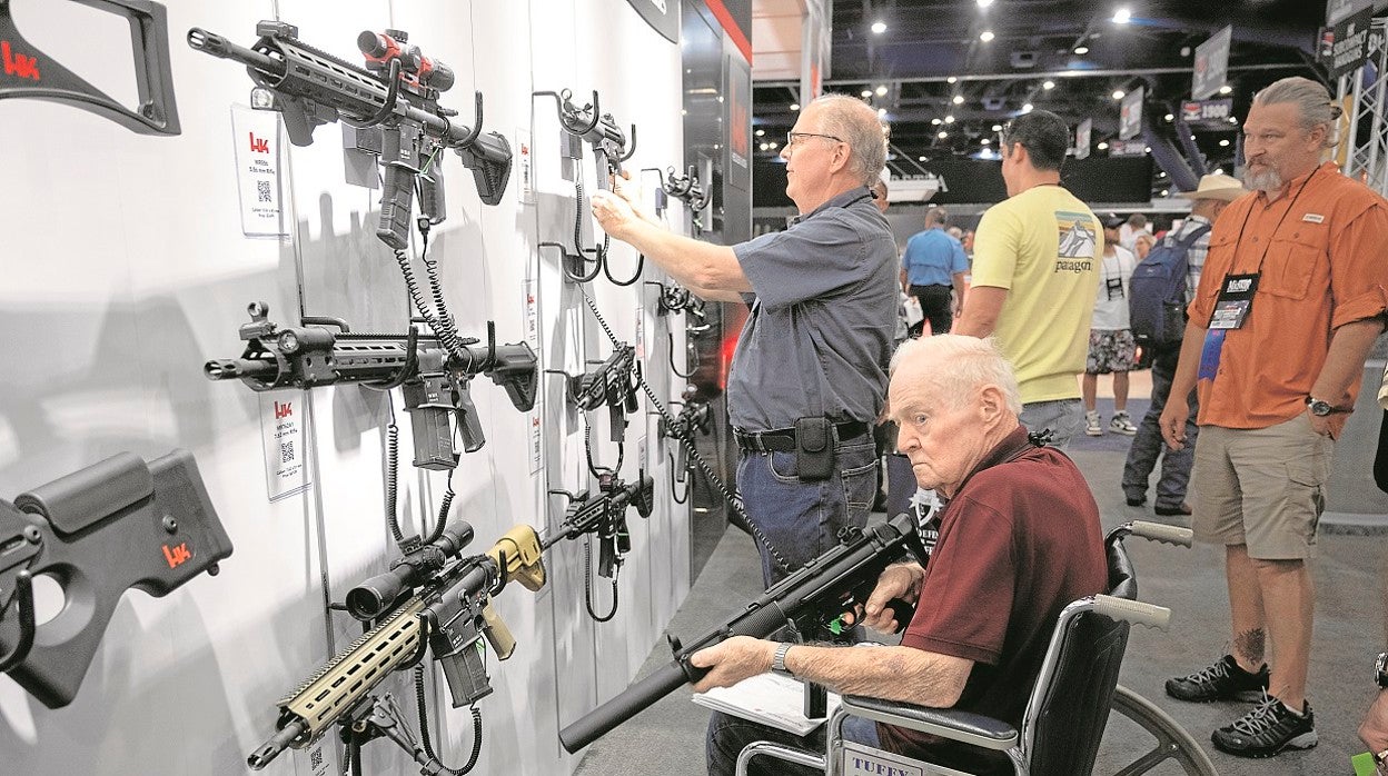 Varias personas inspeccionan distintas armas durante la convención de la Asociación Nacional del Rifle que se celebra estos días en Houston