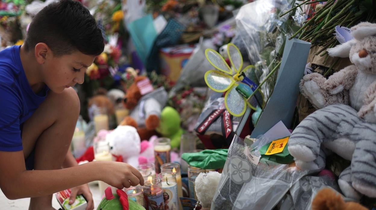 Un niño enciende una vela en el memorial dedicado a las víctimas del tiroteo en Uvalde