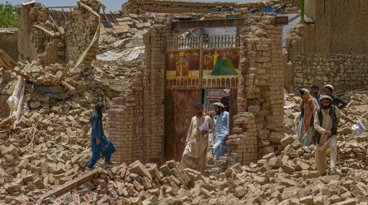 Varios hombres junto con rescatistas examinan el alcance de los daños en una aldea tras el terremoto en el distrito de Bernal, Paktika