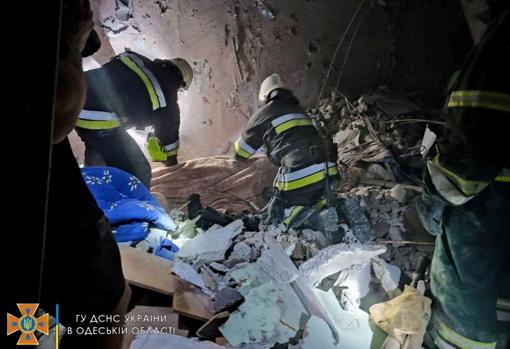 Los bomberos buscan entre las ruinas supervivientes o heridos