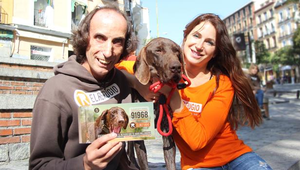 Nacho Paunero enseña el número de la lotería solidaria de El Refugio elegido por Macario