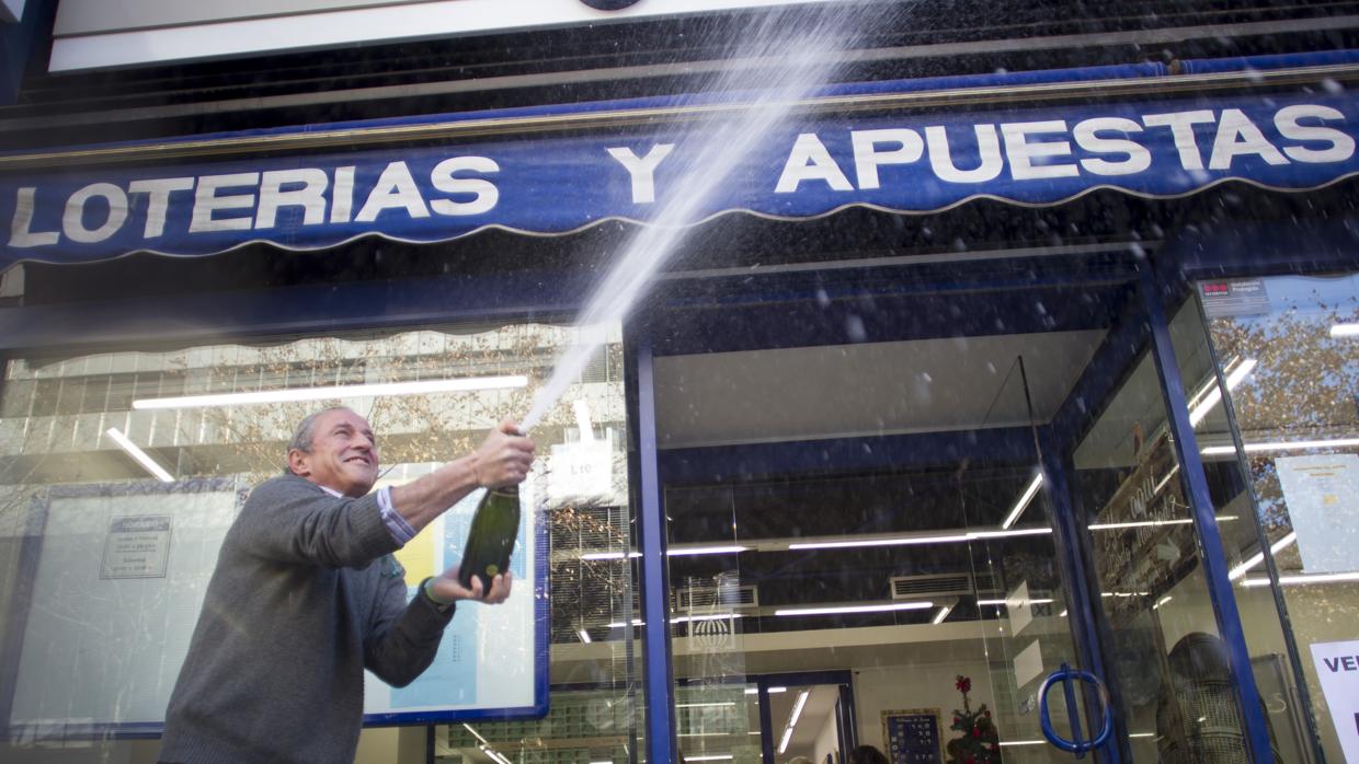 Sergio Martín, propietario de una administración de lotería de la calle Orense, celebra un cuarto premio de la lotería de Navidad en 2015