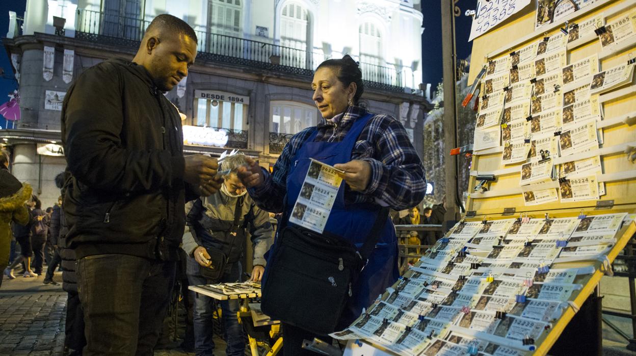 Fotografía de archivo de un hombre comprando un boleto de Lotería de Navidad en la Puerta del Sol