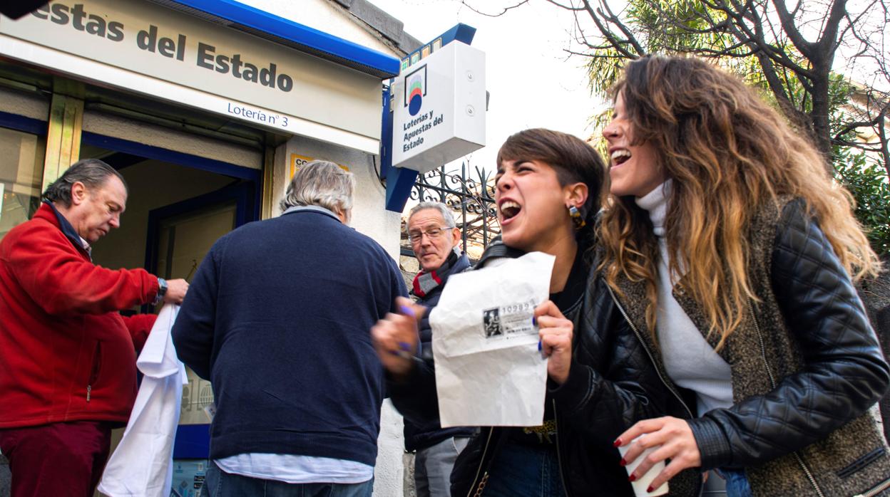 Un grupo de personas celebran en San Lorenzo de El Escorial el segundo premio del Sorteo de la Lotería de Navidad