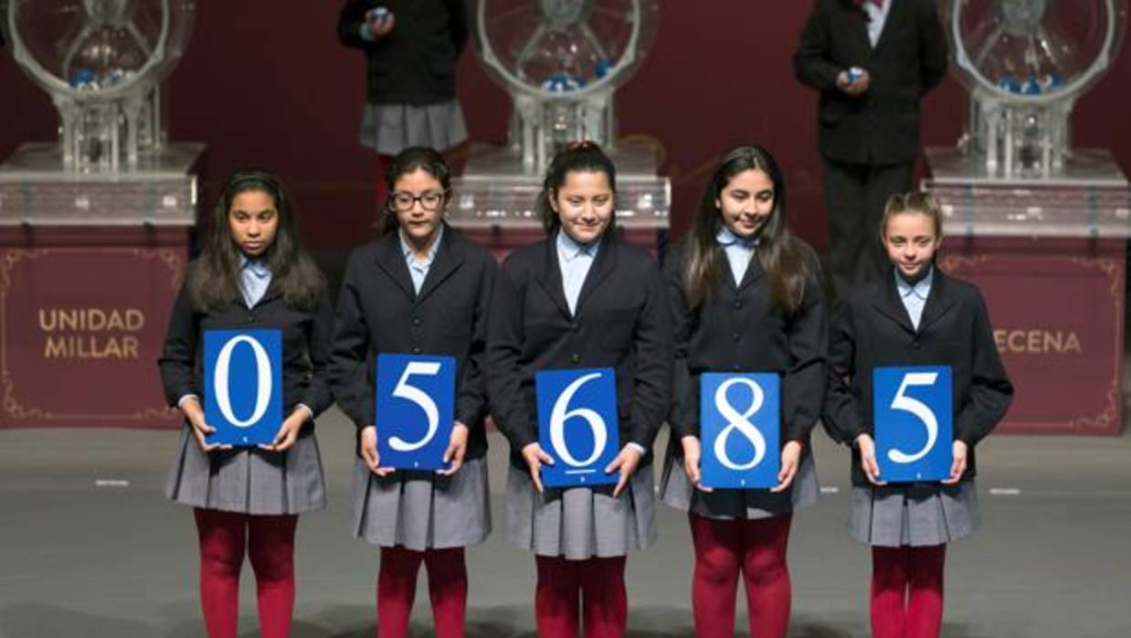 Los niños de San Ildefonso muestran el número agraciado con el primer premio de la Lotería del Niño, que ha recído en el 05.685.