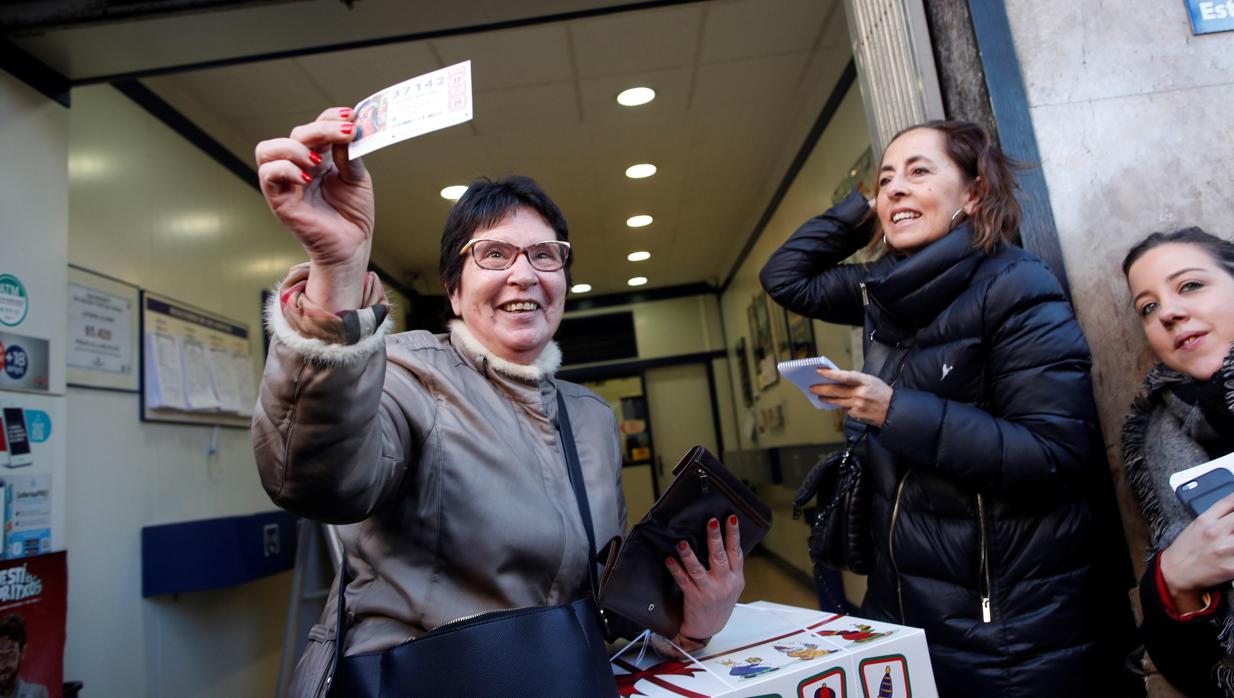 Una agraciada con el primer premio de sorteo de El Niño muestra su décimo con el 37.42