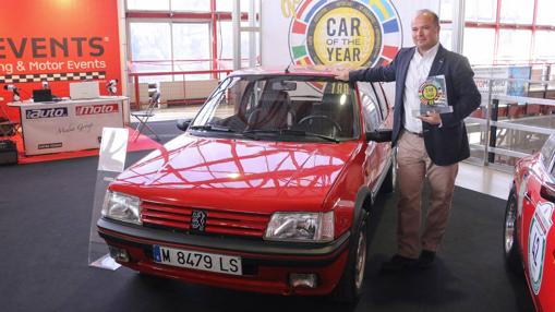 Eduardo García Nieto, director de comunicación de Peugeot, junto al peugeot 205 galardonado
