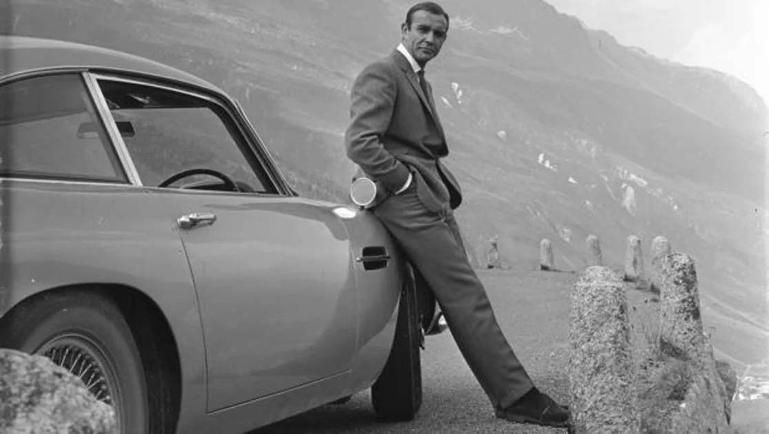 Sean Connery, caracterizado como James Bond, junto a un Aston Martin DB5, en 1964