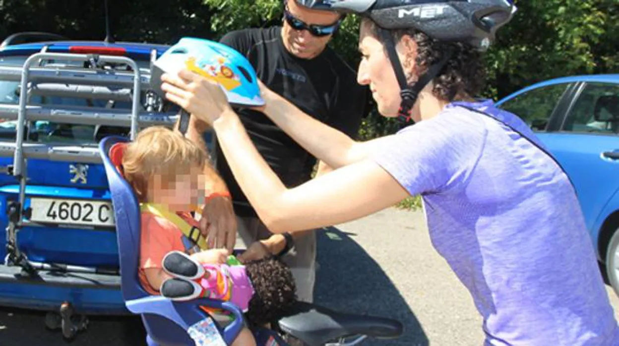 Un niño de tres años, con un casco de bicicleta y gafas de sol en