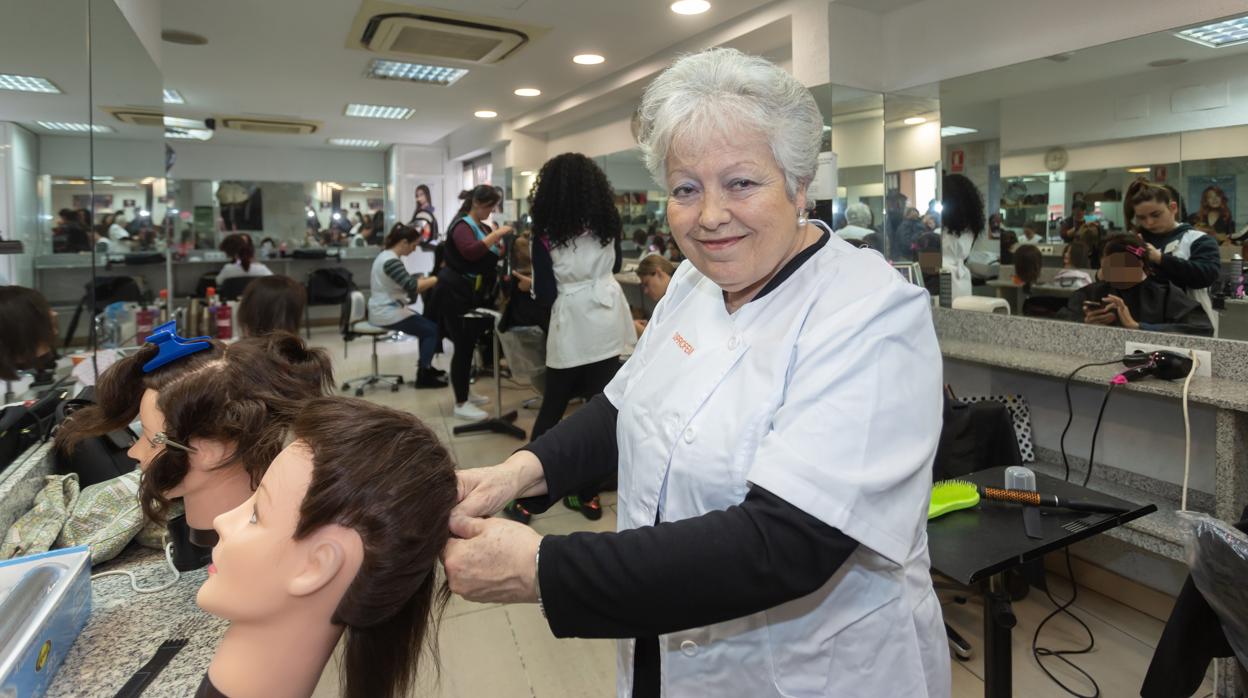 Rosalía en la academia aprendiendo sobre un maniquí a hacer una trenza de raíz