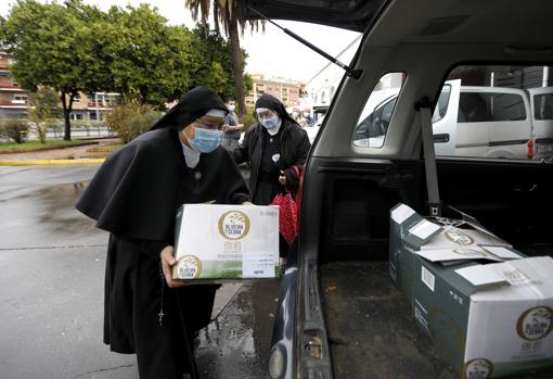 Unas religiosas recoge comida en el Banco de Alimentos Medina Azahara