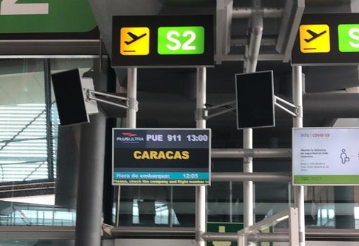El vuelo PUE911, con destino a Caracas, anunciado en la pantalla del aeropuerto de Barajas