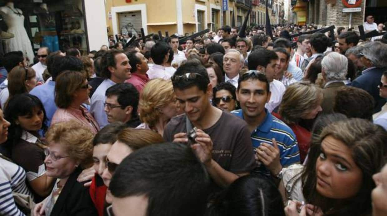 Sevillanos agolpados para ver una procesión de Semana Santa