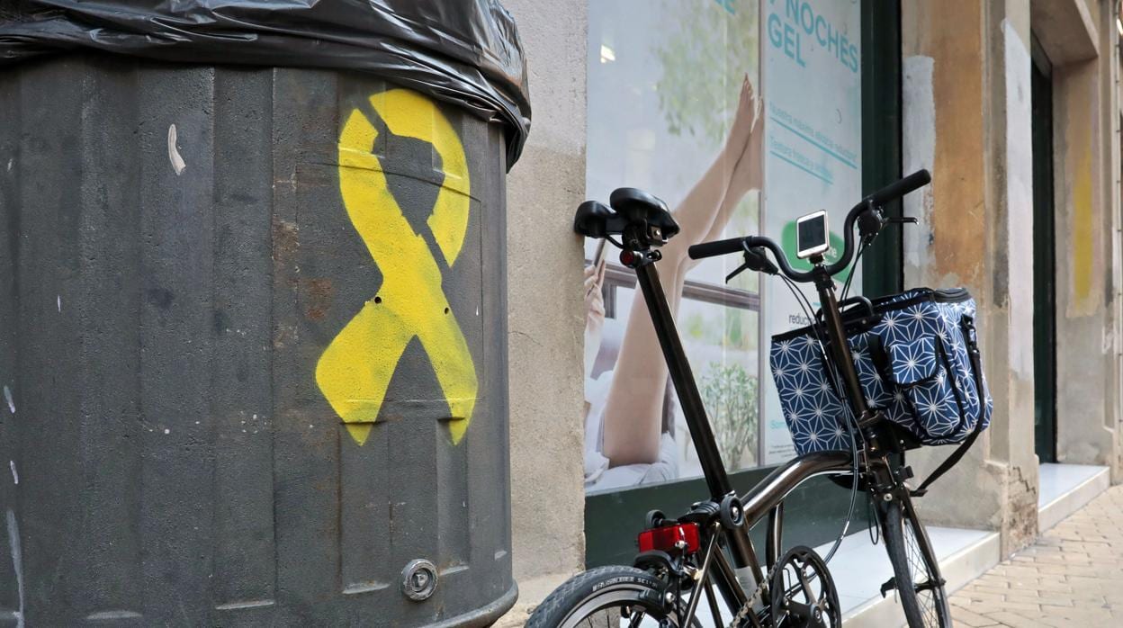 Un lazo amarillo pintado en una papelera de una calle de Barcelona