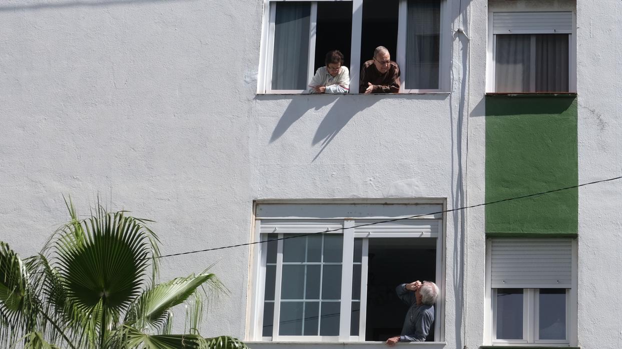 Unos vecinos hablan a través de la ventana durante el confinamiento.