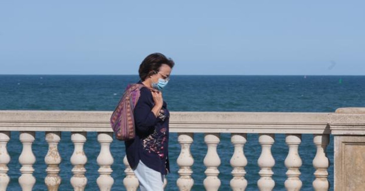 Una mujer con mascarilla pasea por Cádiz.