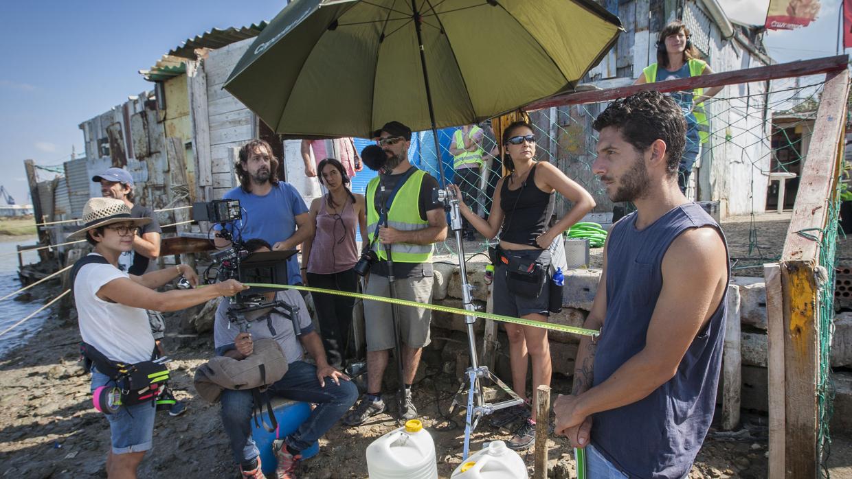 Los directores Isaki Lacuesta e Isa Campo (al fondo), junto al actor Israel Gómez (derecha), posan durante el rodaje de «Entre dos aguas» en San Fernando y Rota (Cádiz)