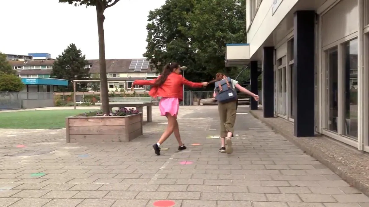 Una niña intenta agredir a otra más pequeña a la salida de un colegio en el vídeo "Tras la máscara".
