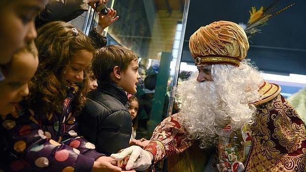 Melchor, repartiendo caramelos entre un grupo de niños