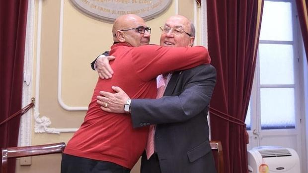 González Bouza y Martín José García se abrazan tras la firma.