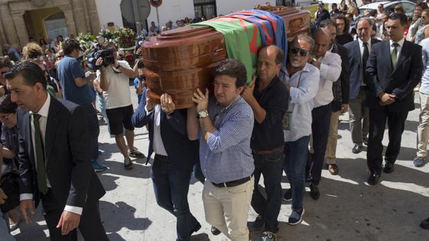 El féretro cubierto por la bandera del pueblo gitano y portado por familiares y amigos