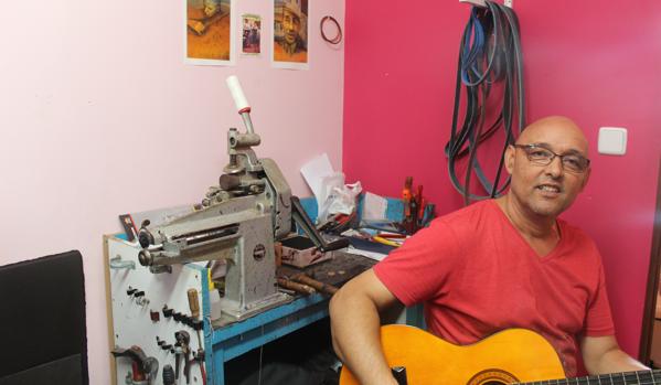 Ignacio Zambrana con su guitarra en su taller de zapatería