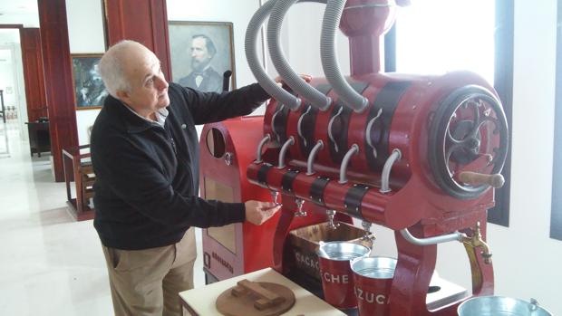 Antonio Rivero, fundador del museo, junto a unas de las antiguas máquinas chocolateras