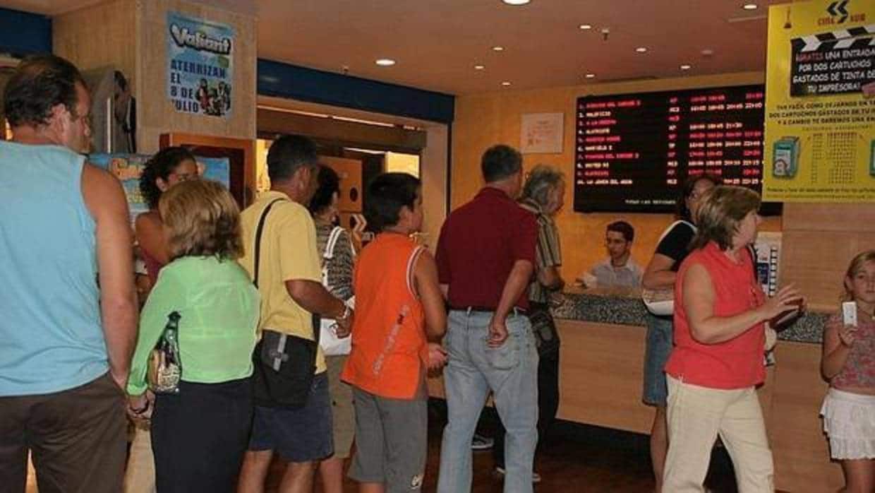 Los aficionados hacen cola para comprar una entrada en el cine.