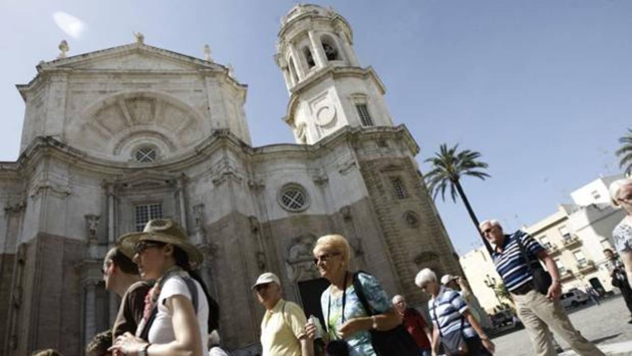 Turistas británicos pasean delante de la catedral de Cádiz.